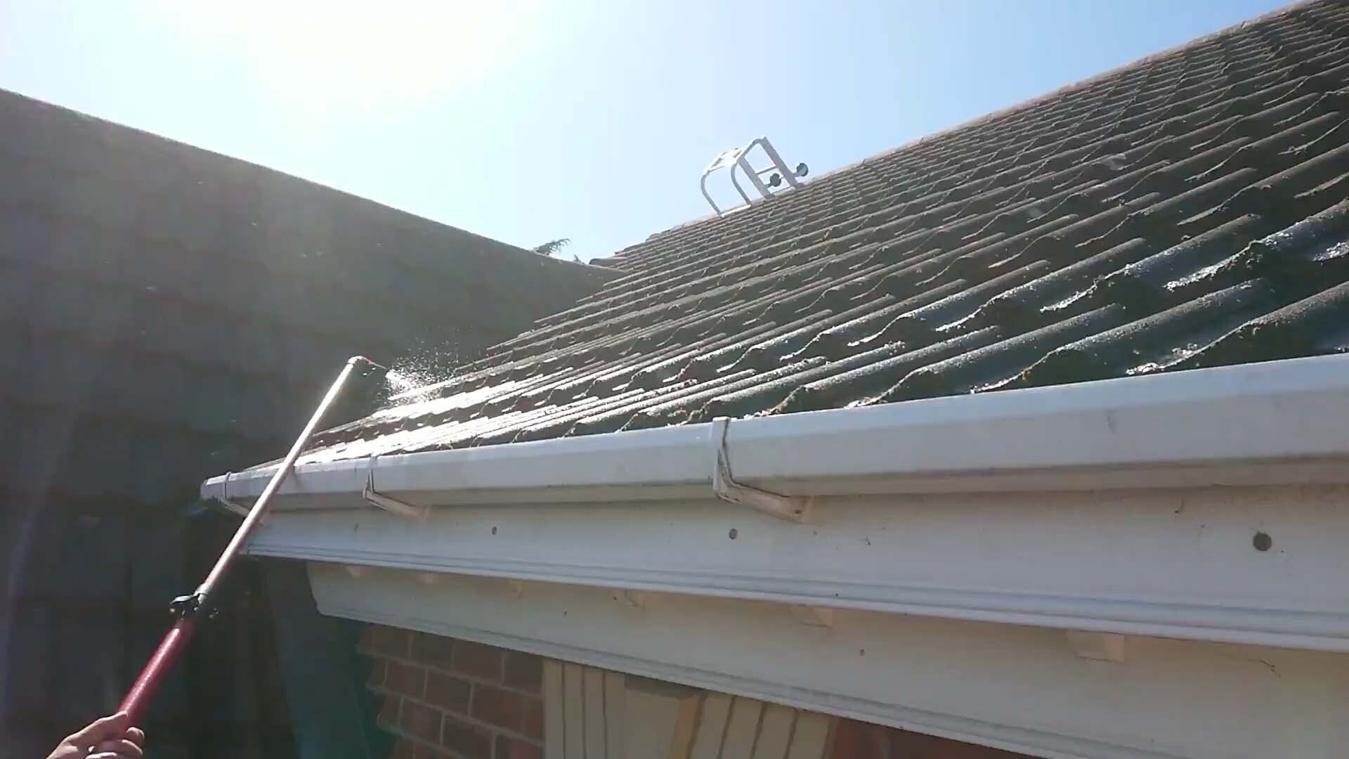 Pole washing the gutter and roof edge of a house