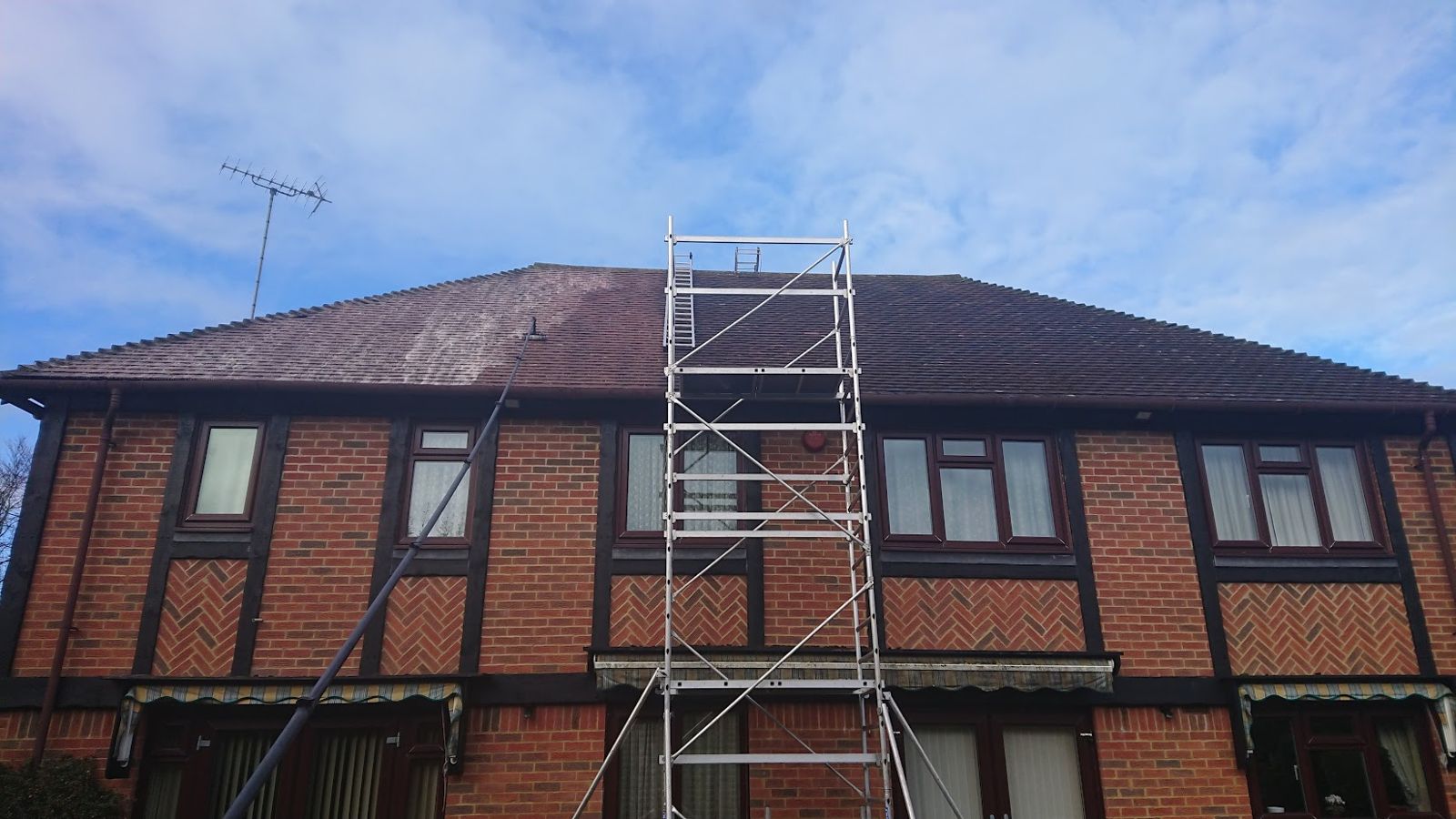 Roof partly cleaned, showing the clean side beside the mossy side