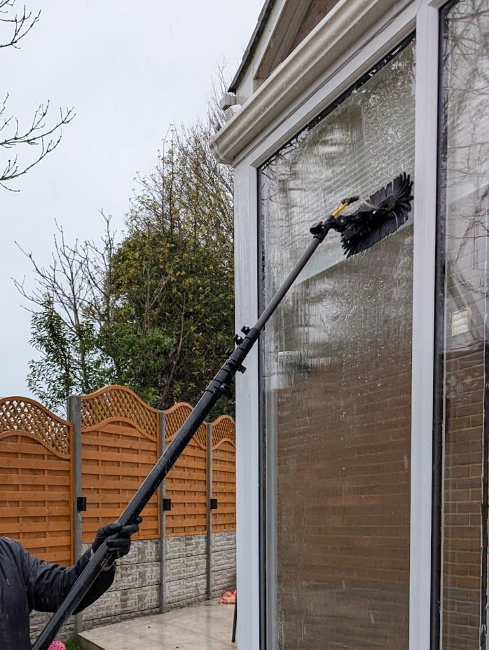 Window being cleaned with a water-fed pole brush